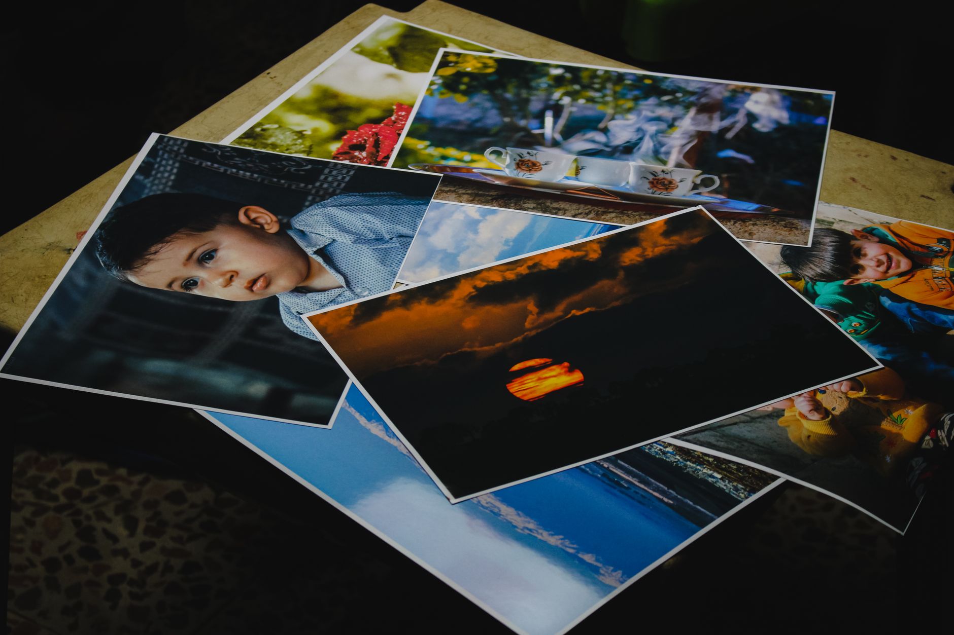 a spread of large-format photographic prints fanned out on a table