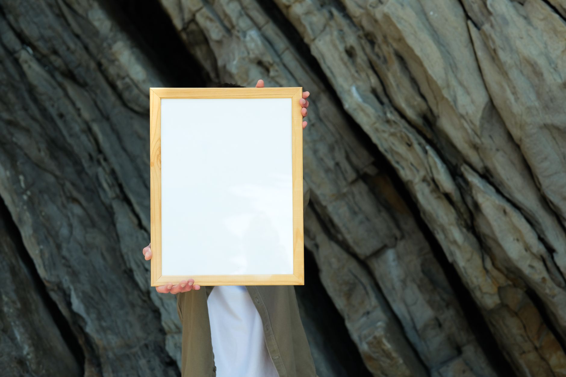 a person holding a blank timber poster frame ready for an insert