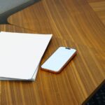 a stack of A5 saddle-stitch booklets with a gloss laminate cover fanned out on a white table in a studio setting