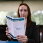 a reader holding a printed A5 event program booklet