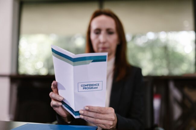 a reader holding a printed A5 event program booklet