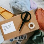 a row of white address labels printed with a business name and address, peeled from a sheet and applied to kraft paper padded bags on a