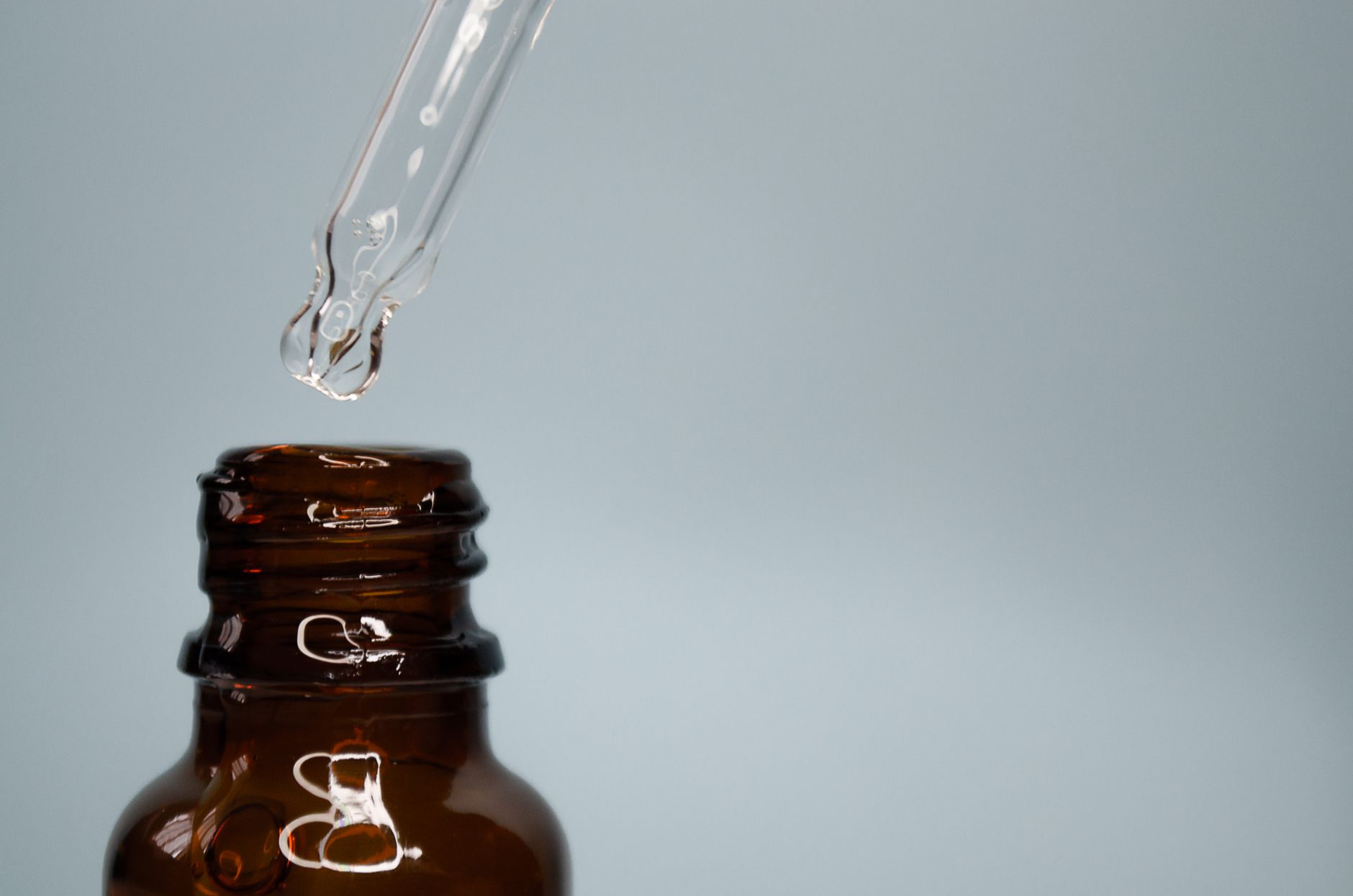 an amber glass dropper bottle, a common surface for clear waterproof labels