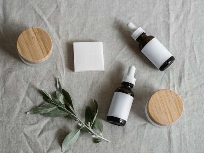 amber dropper bottles and a soap bar styled with botanical sprigs on linen