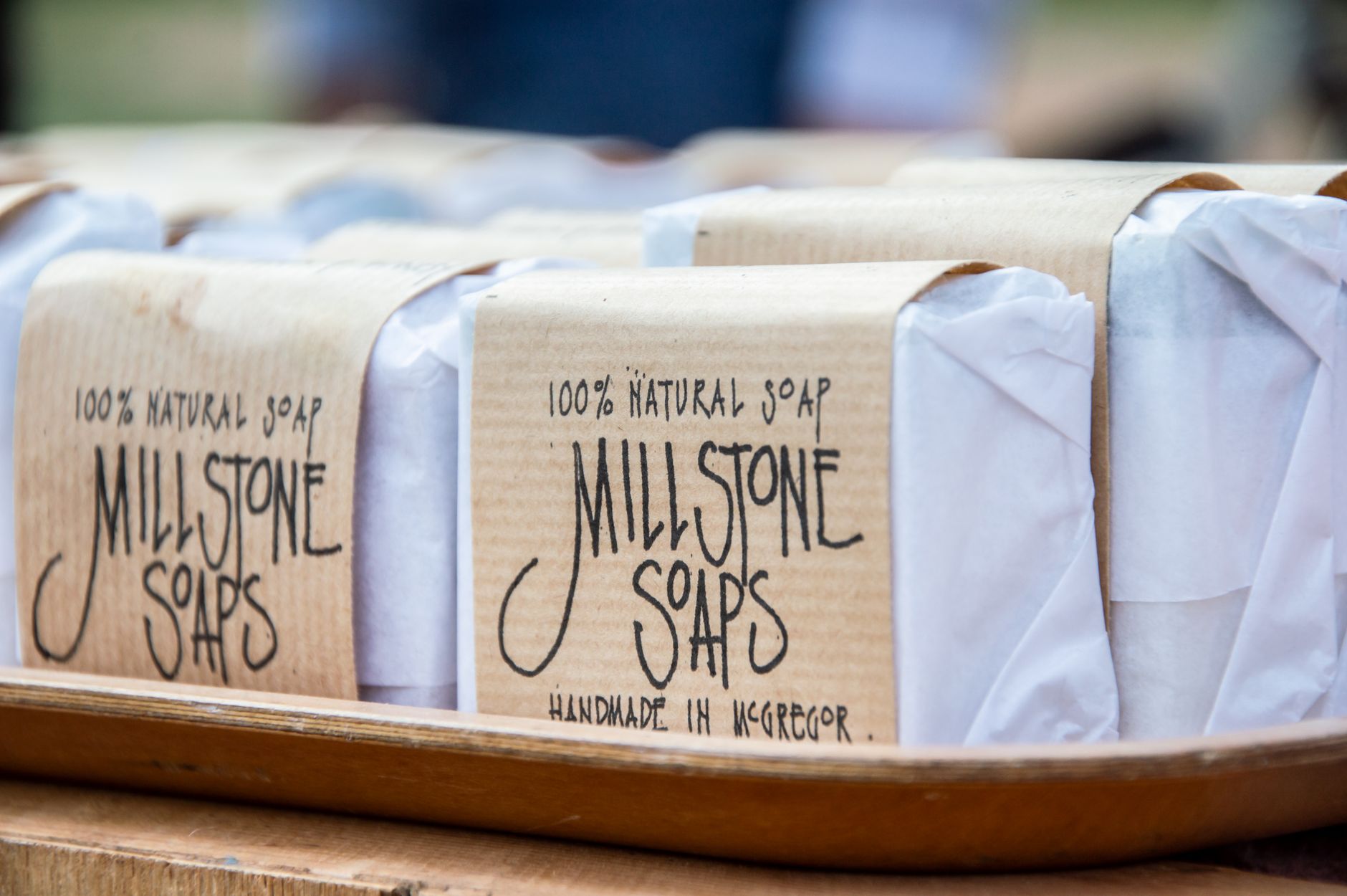 handmade soap bars wrapped in printed kraft band labels on a tray