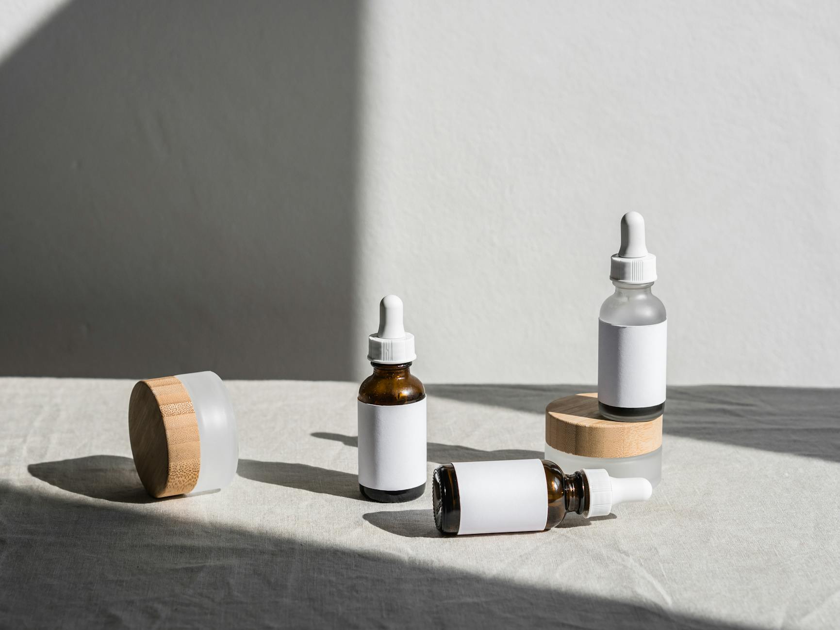 white and amber cosmetic bottles with clean printed labels on a white table