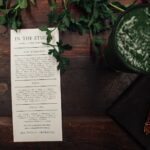 a well-designed A5 event flyer laid flat on a wooden desk beside a coffee cup, showing bold headline text and a clear call-to-action button