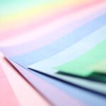 a fanned spread of paper sheets in a range of pastel colours