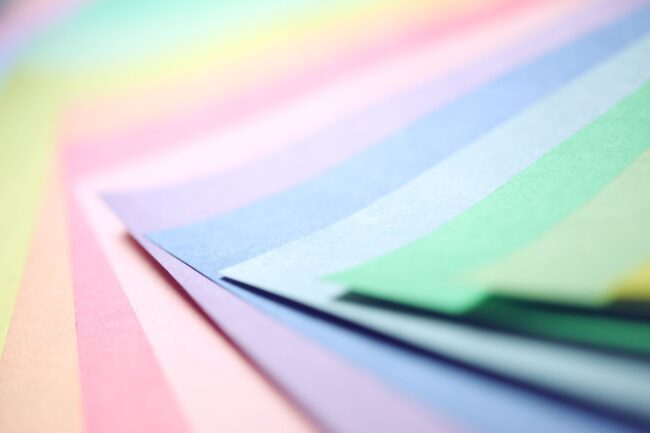 a fanned spread of paper sheets in a range of pastel colours