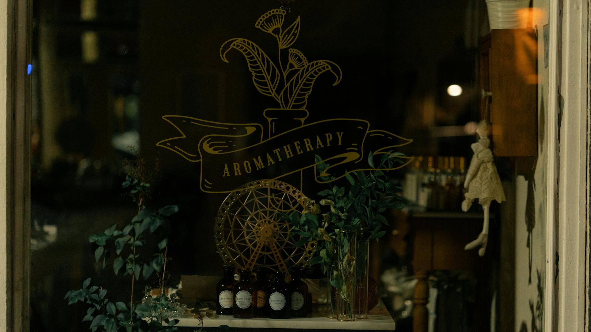 a cafe window with full-colour vinyl decals showing a logo, opening hours, and a promotional message, viewed from the footpath