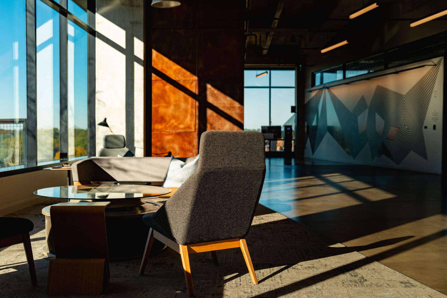 a modern office reception area featuring a large acrylic panel sign with a company logo mounted on a feature wall behind the reception