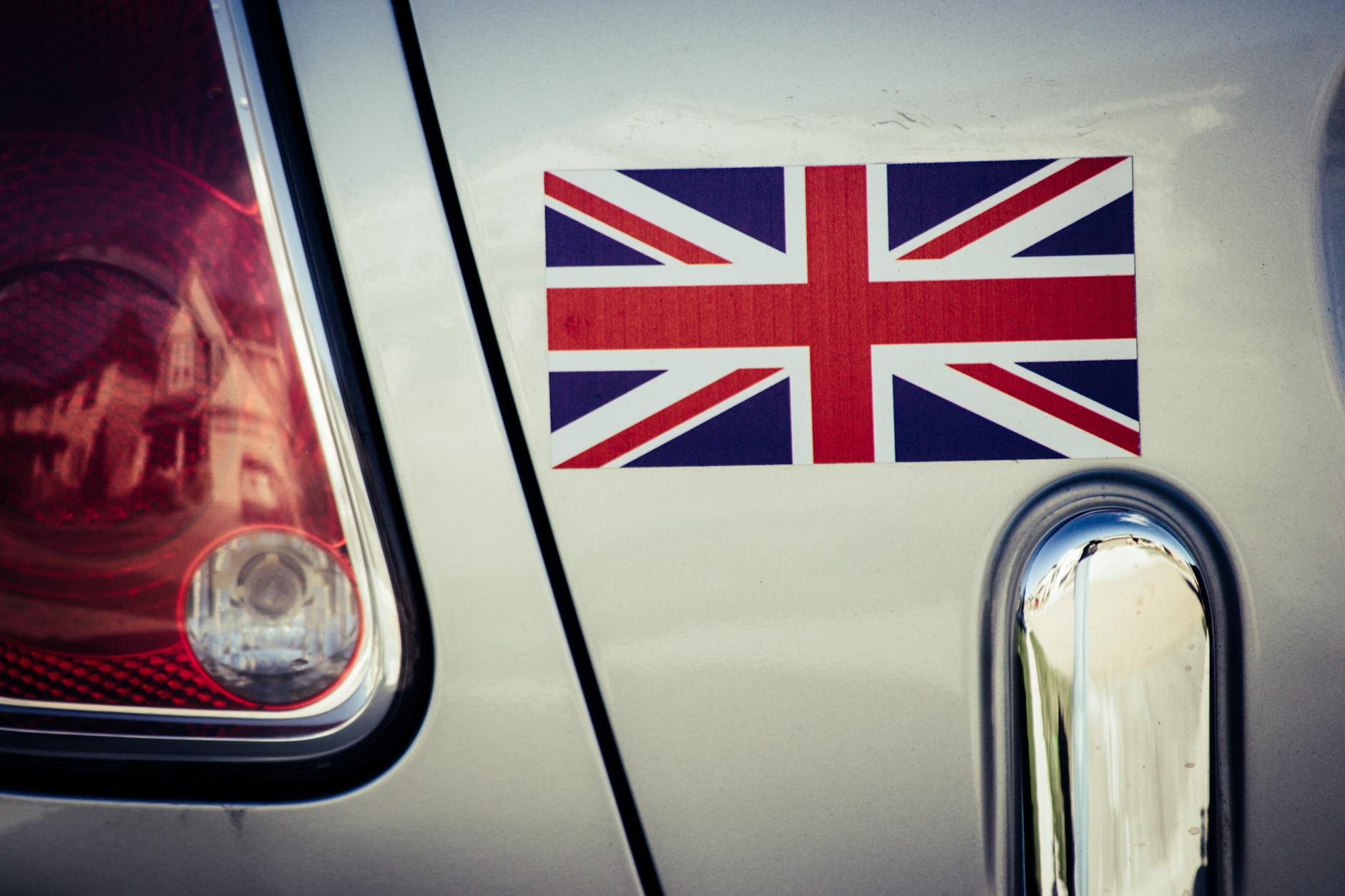 a printed Union Jack vinyl sticker applied to the rear panel of a car beside the tail light