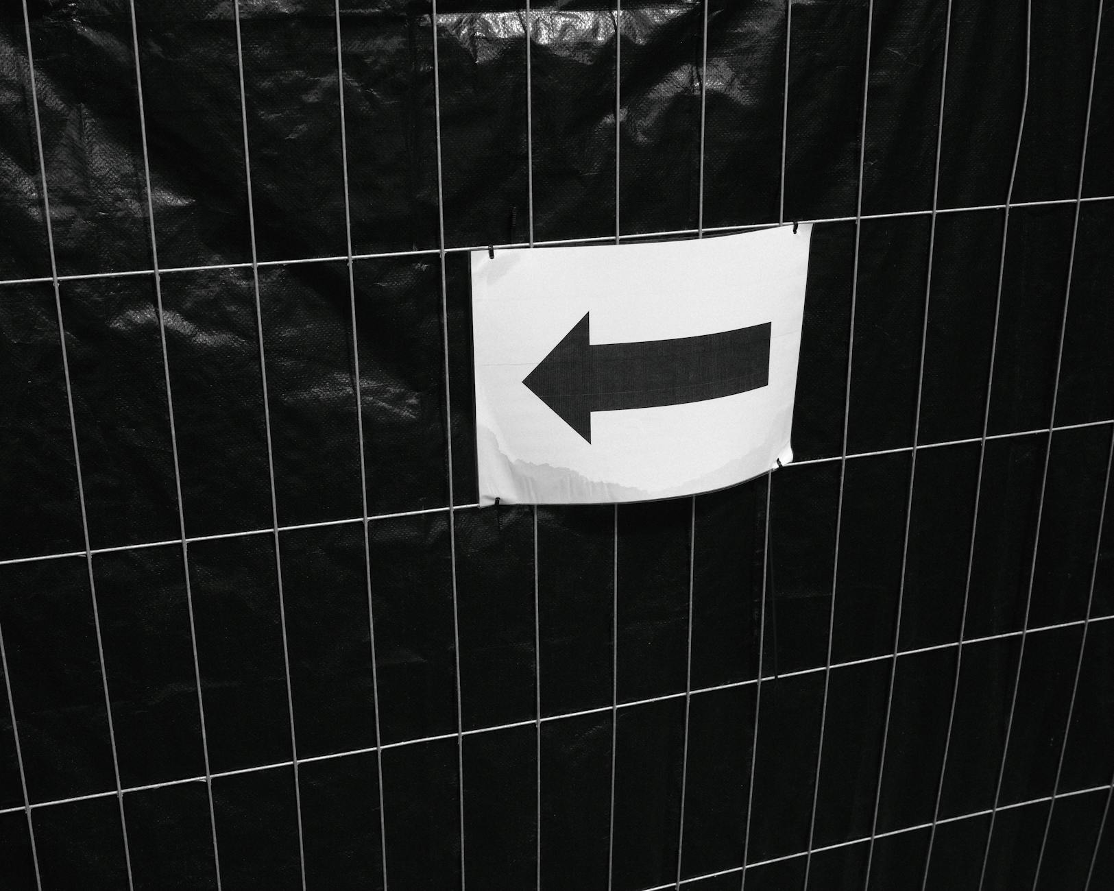 a 600x900mm corflute site sign zip-tied to a temporary construction fence outside a residential renovation, showing a builder's logo