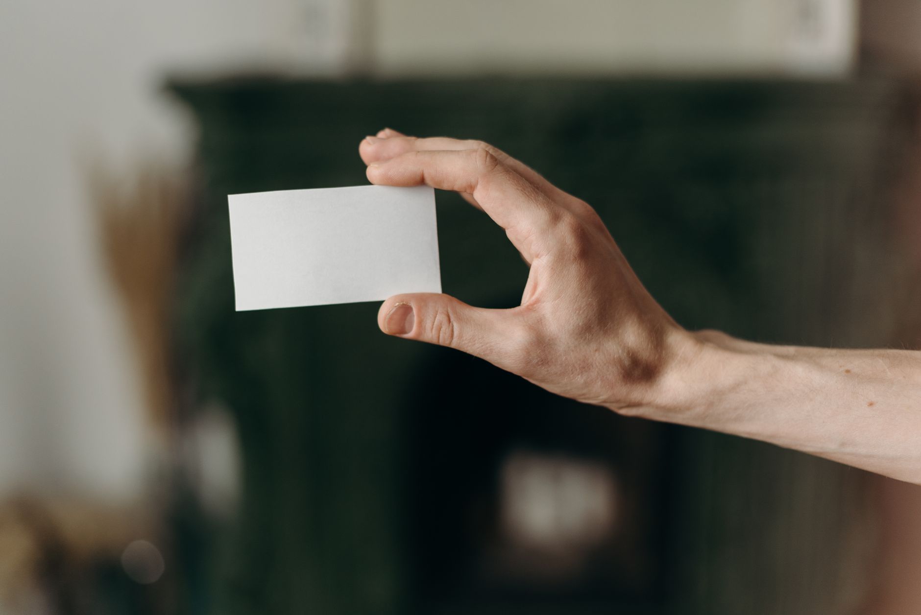 a tradie handing a business card to a homeowner on a front doorstep, both standing in front of a freshly painted exterior