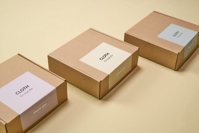 flat lay of branded online order packaging with die-cut logo sticker on a mailer bag, rectangle product label, swing tag on an artisan