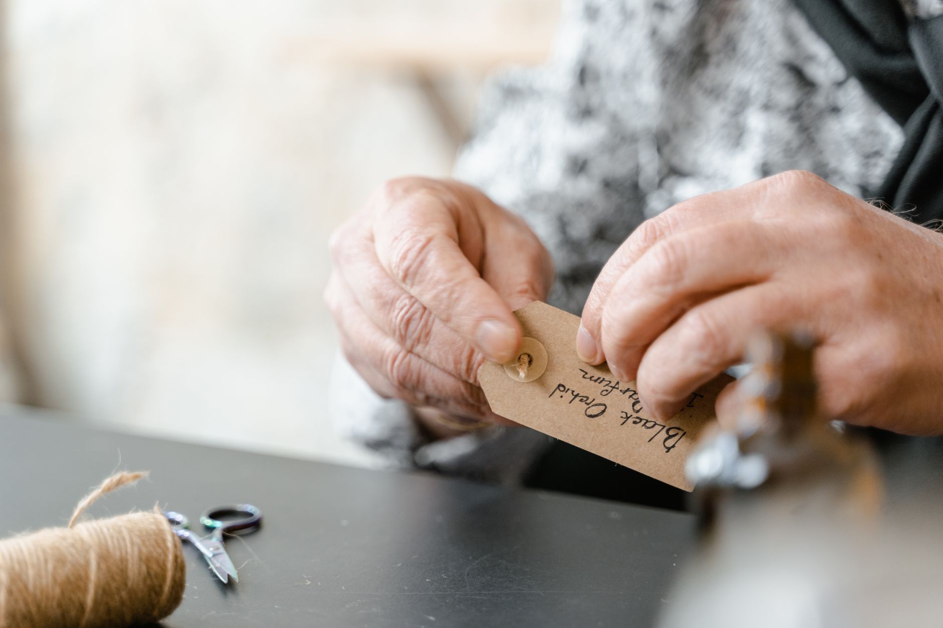 three artisan swing tags attached to handmade jewellery pieces, showing clean logo print, product name and barcode on kraft card