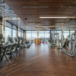 a bright modern gym floor with rows of fitness equipment