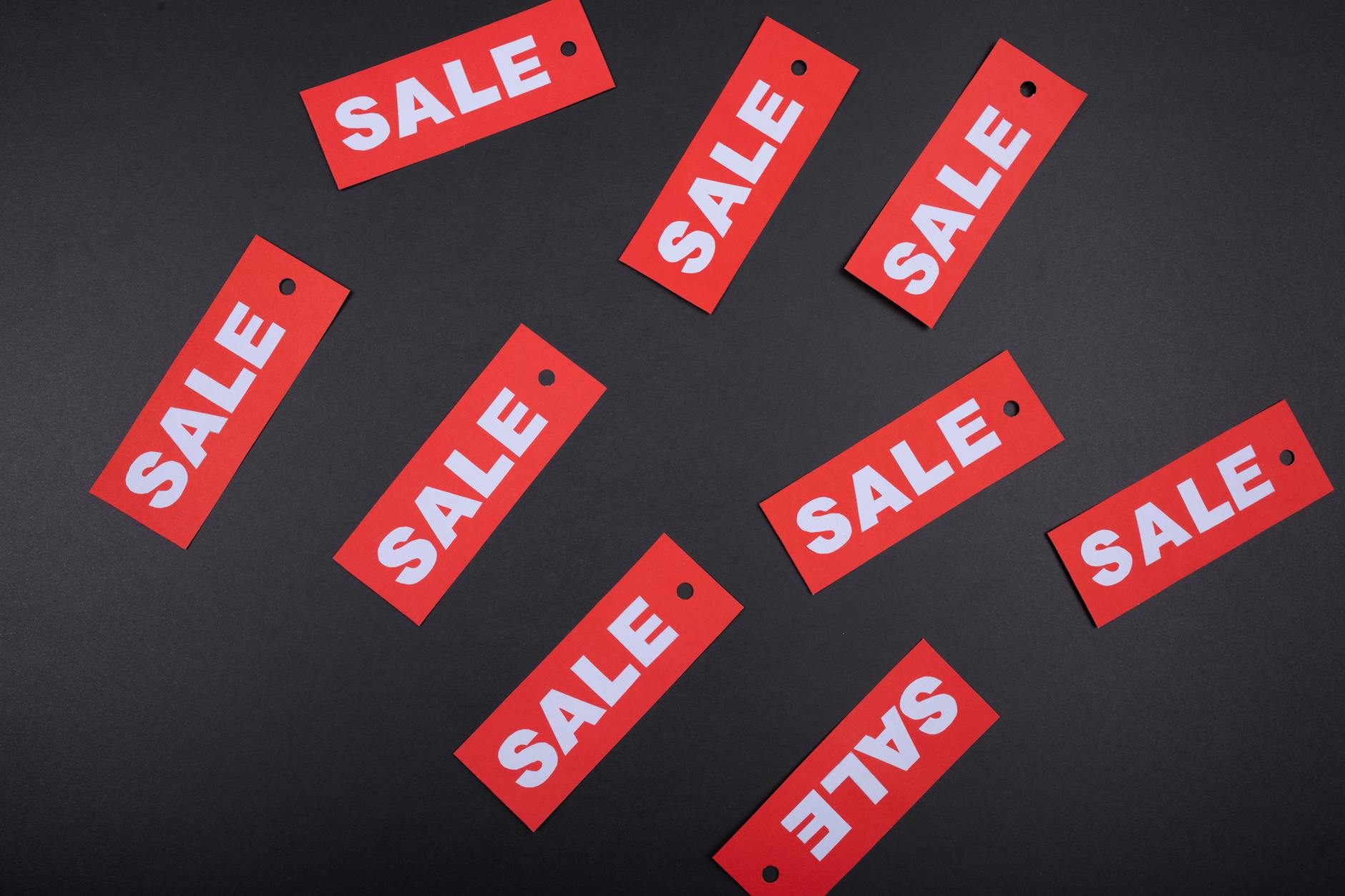 red sale tags fanned out on a dark surface