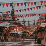 colourful bunting strung above market stalls at a busy outdoor festival