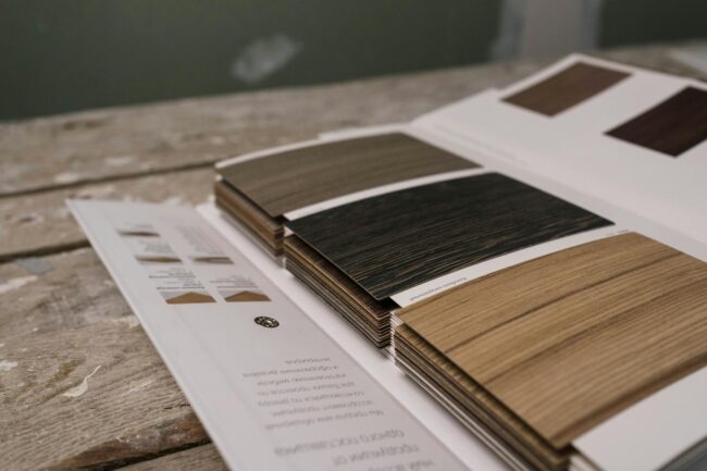 side-by-side samples of corflute, foam-PVC and acrylic sign materials laid flat on a workbench, showing cross-section thickness differences