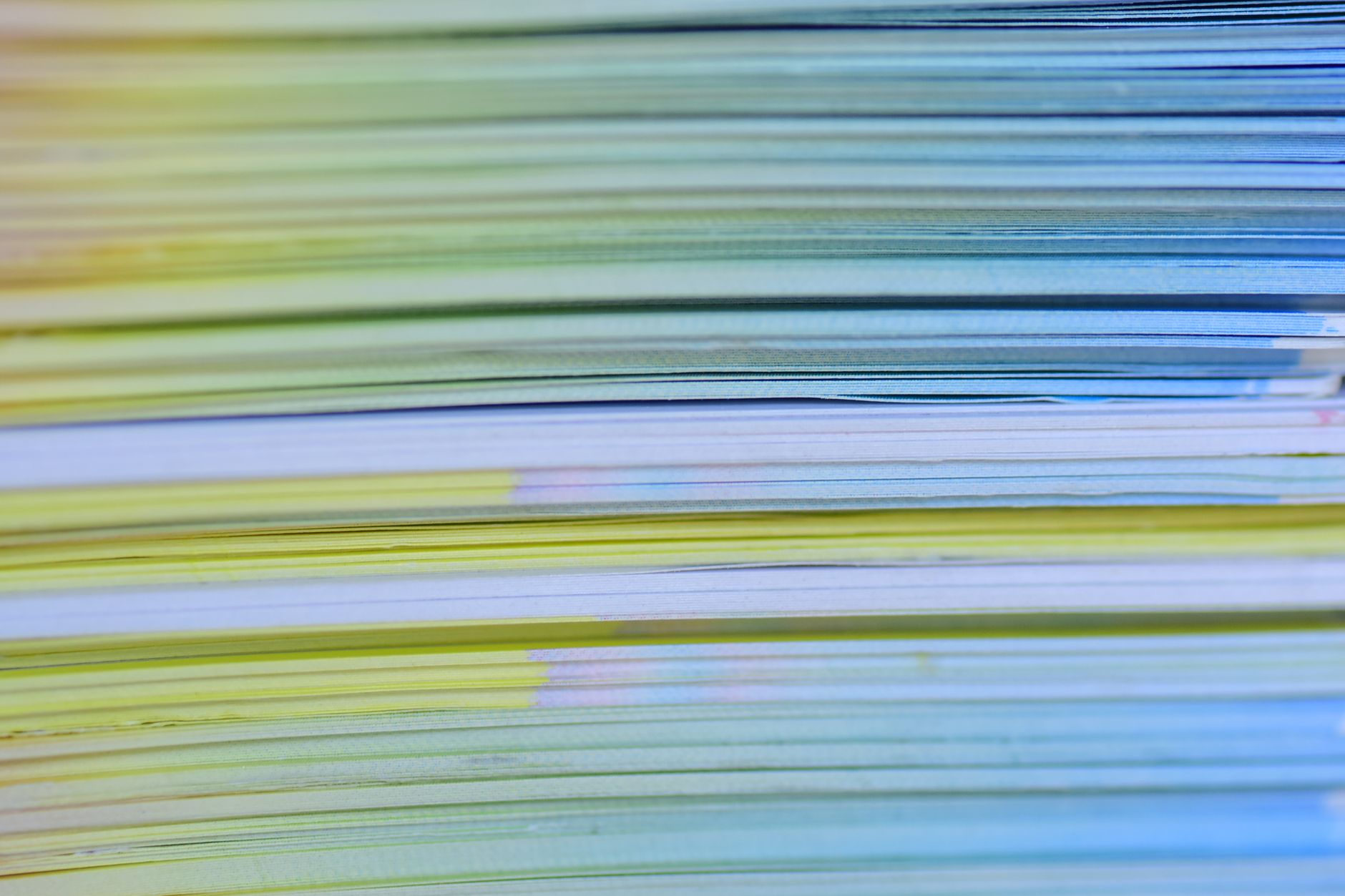 a close-up of stacked sheets of coloured printing paper showing their cut edges