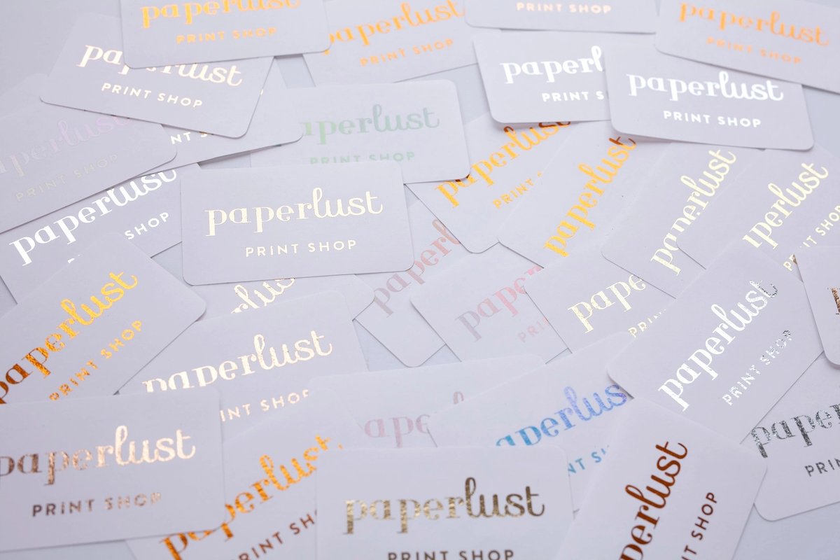 Metallic foil stickers in gold, copper and blue scattered on a soft neutral surface