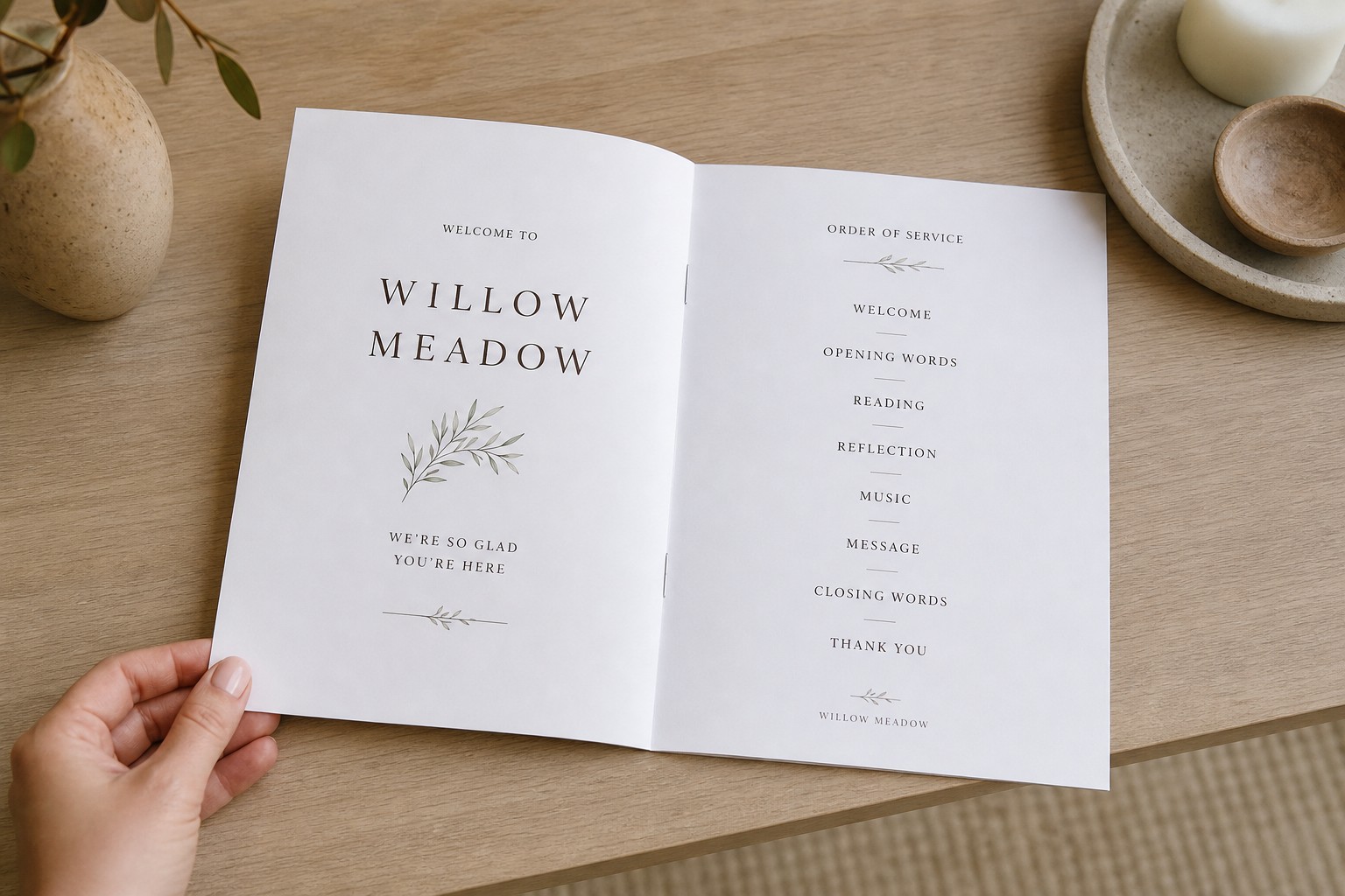 An open A5 saddle-stitched service booklet laid flat on a pale timber surface