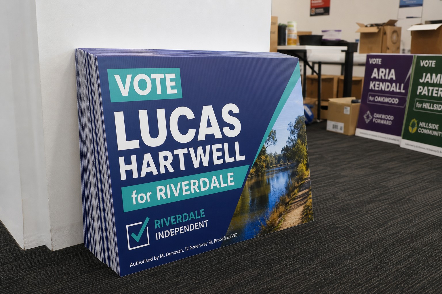 Freshly printed corflute election signs stacked in a campaign office, showing vivid full-colour UV printing on 5mm fluted plastic ready for distribution