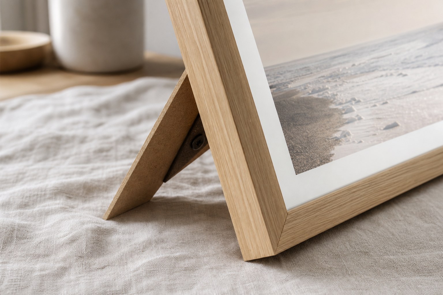 Close-up of an oak framed print corner with plexiglass and a fold-out stand