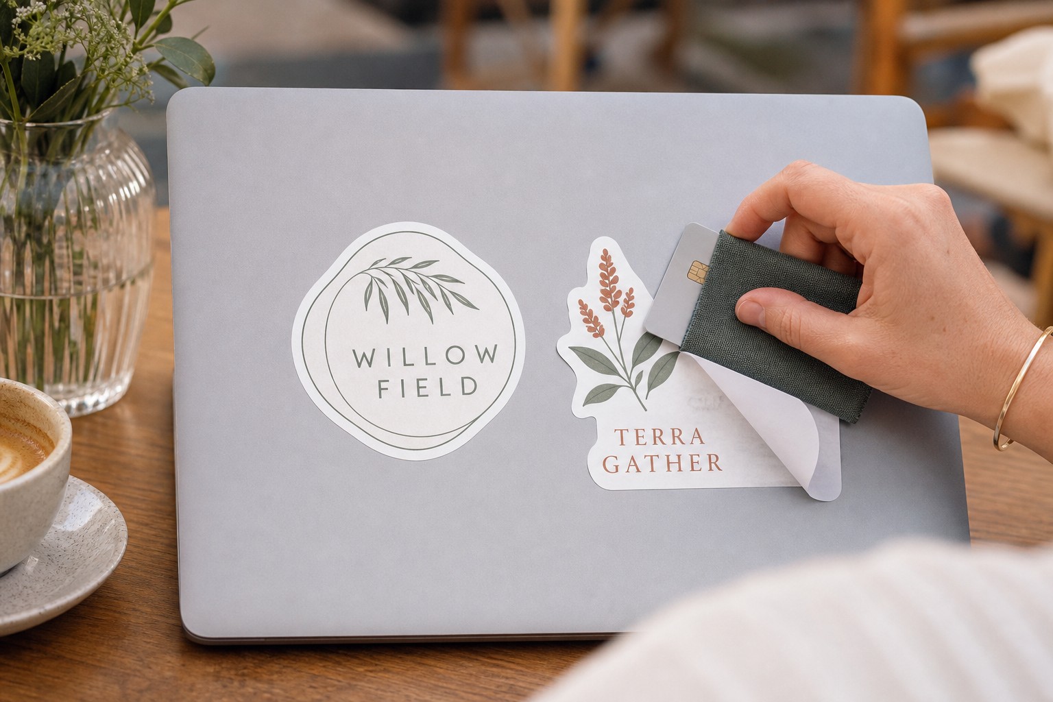 Two custom die-cut vinyl stickers on a silver laptop lid