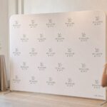 Step-and-repeat media wall · 230gsm stretch polyester · dye-sublimation print · matte finish · aluminium frame on two slim silver feet