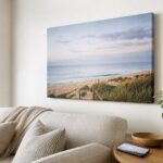 Coastal canvas print on a wall beside a phone showing the same image