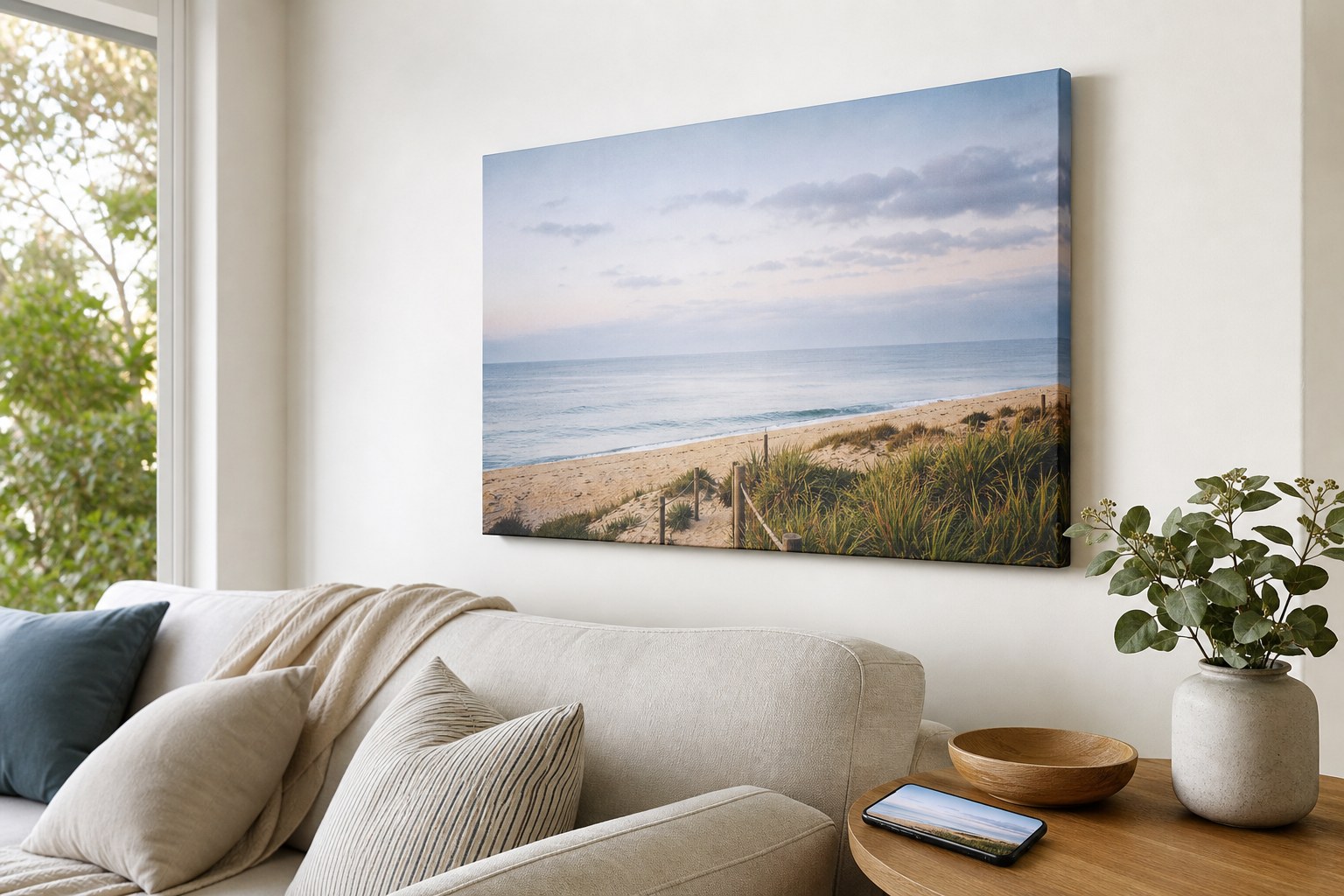 Coastal canvas print on a wall beside a phone showing the same image