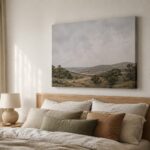 Large gallery wrap canvas print of a soft landscape hanging above a timber bed head in a calm bedroom