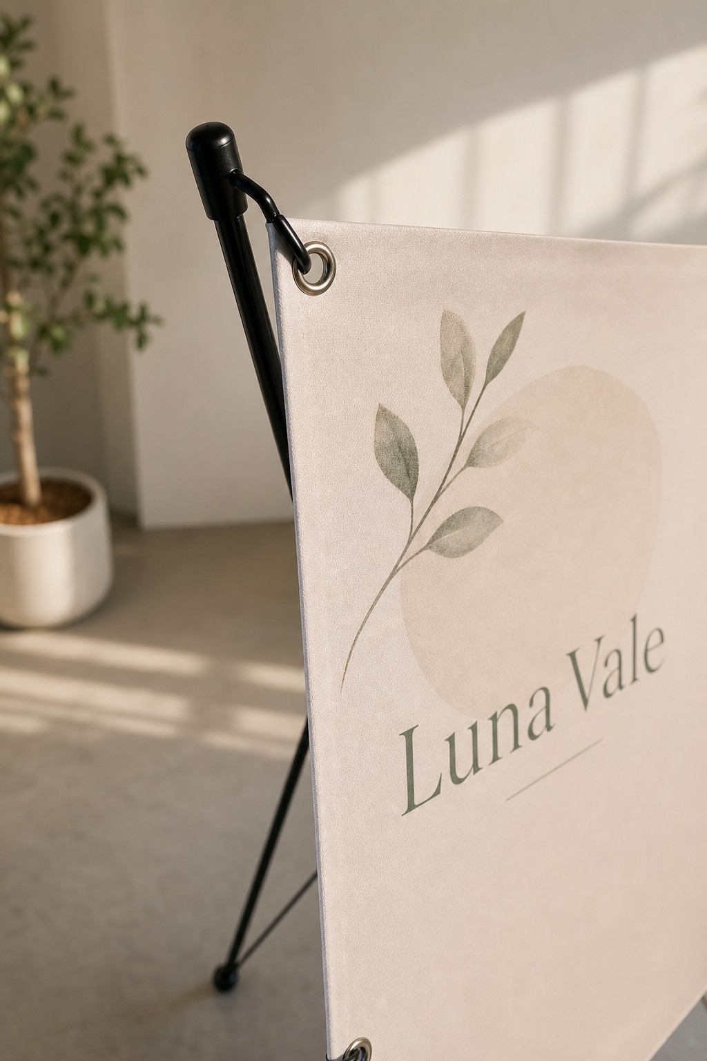 X-banner panel corner · 440gsm polyester · full-colour print · matte finish · eyelet hooked onto the X-frame arm