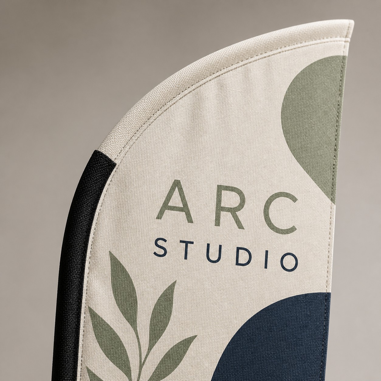 Bow banner fabric close up with cream sage green and navy leaf print, flexible pole edge and fabric weave visible.