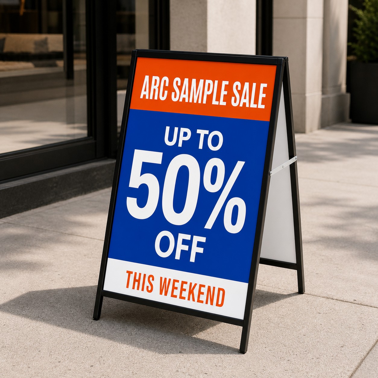 A-frame sign with laminated portrait panel, orange, blue and white print, black powder coated steel frame and support strut at a shopfront