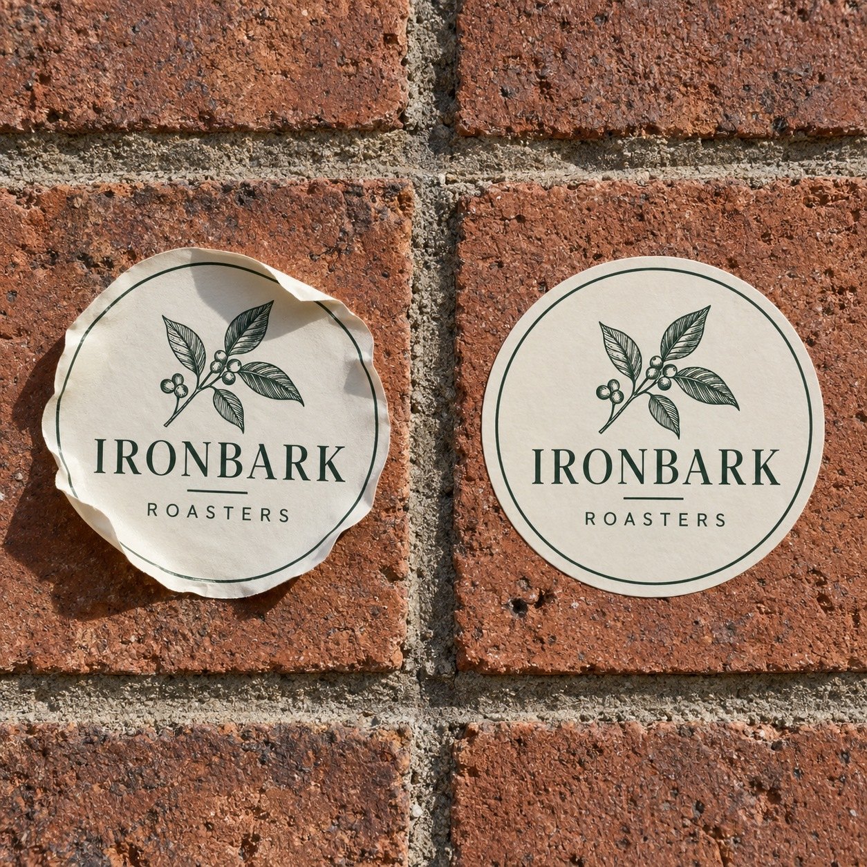 Two identical round cream stickers with green keyline on brick, left standard edges curling, right high tack sticker flat