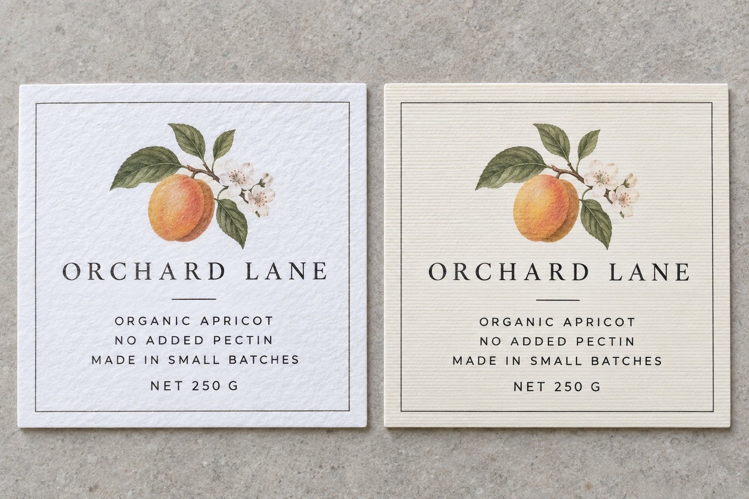 Two rectangle stickers with ingredients panel and small text, bright white felt left and warm cream linen right on grey stone