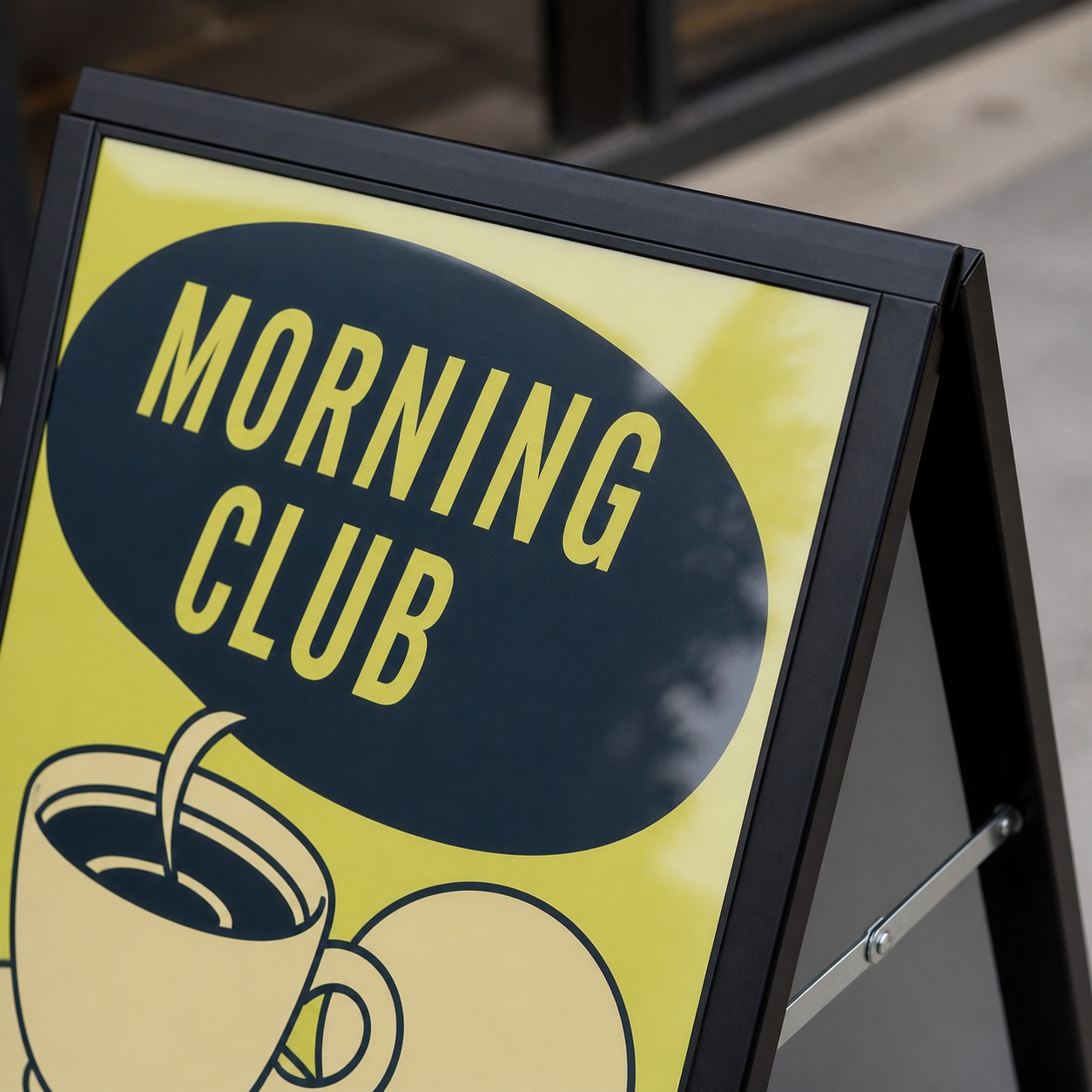 A-frame sign close up with black snap open hinged edge lifted from clear cover, metal hinge visible and yellow, navy and black print