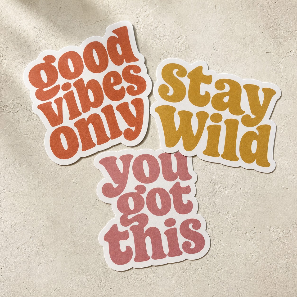 Three loose die cut stickers on pale plaster · White Gloss Sticker or White Matte Sticker · No Laminate, Matte Laminate, or Gloss Laminate