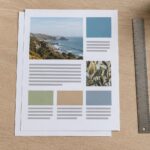 Two sheets of paper on an oak desk with a steel ruler, pencil, photo layouts, color blocks, and gray lines