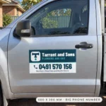 Magnetic car door sign on a silver ute driver door with a dark teal upper panel and a white panel below for a large phone number and service area.