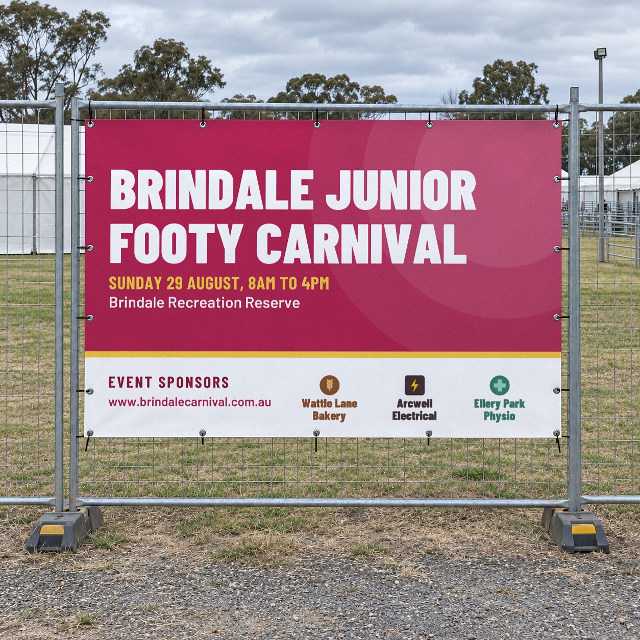 A magenta mesh event fence banner tied to temporary fence panels beside a gravel path