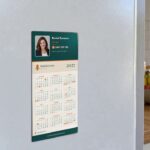 Fridge magnet calendar in Real estate agent layout with teal header and agent photo above twelve months on white fridge door