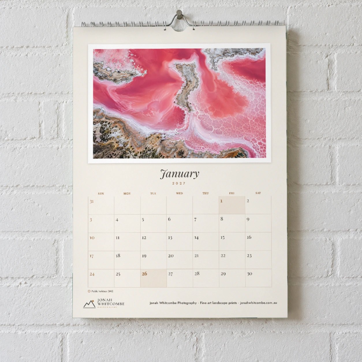 Wall calendar in Framed layout on white brick wall with pink salt lake photo in white mount, January above fine line grid