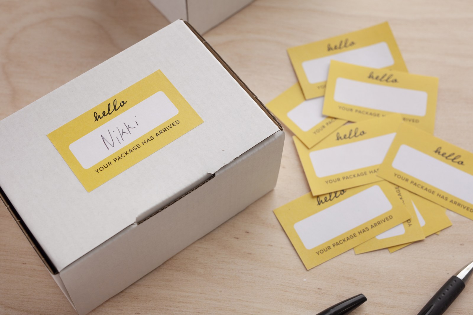 Yellow rectangle sticker on a white mailer box · Rectangle Stickers in White Gloss or White Matte stock · optional no, matte, or gloss laminate